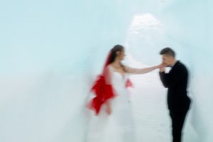 Blurry photos are part of a new photography trend-- this one shows how the color of the red veil and the style of photography create a completely different mood for these bridals at the Ice Castles.