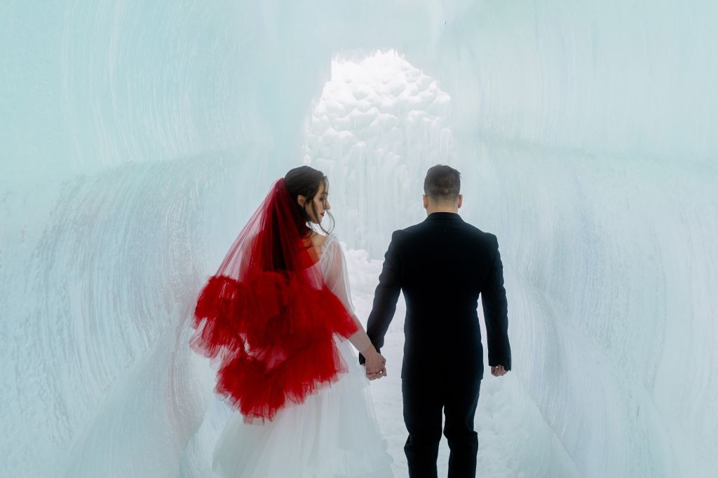 In the shadows of a tunnel at the Midway Ice Castles, the red drop veil on Kalli takes on a different hue almost. Red is very reactive to light as a color, and this shows a perfect example of how as the sun fades, your veil could help set a new mood for the evening.